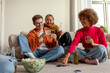 © Богдан Маліцький - multiracial group of young friends playing cards drinking beer and having fun at home, students sitting on the floor