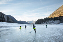 People playing ice hockey on frozen Lake Lodensee, Germany