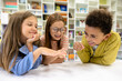 © zinkevych - Children sitting in school library having fun while break