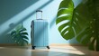 Blue luggage facing camera against the wall has palm leaf shadows 