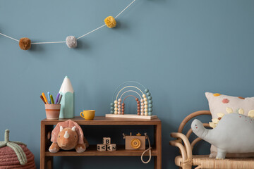 Wall Mural - Aesthetic composition of warm child room interior with wooden sideboard, blue wall, stylish armchair, garland on wall, plush monkey, toys, wooden camera and personal accessories. Home decor. Template.