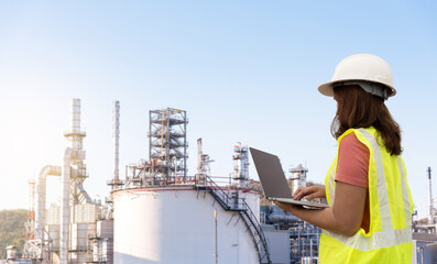 Wall Mural - Young female engineer controls a large oil refinery.