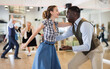 © caftor - Woman with african man practising charleston dancing