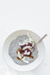 Wall Mural - Chia pudding with jam and coconut chips in white plate. Vegan breakfast concept.