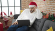 © Krakenimages.com - African american man watching video on laptop celebrating christmas at home