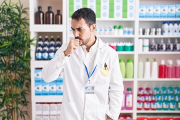 Poster - Handsome hispanic man working at pharmacy drugstore feeling unwell and coughing as symptom for cold or bronchitis. health care concept.