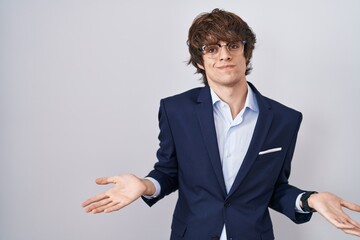 Canvas Print - Hispanic business young man wearing glasses smiling cheerful with open arms as friendly welcome, positive and confident greetings