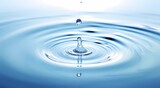 Fototapeta Łazienka - A single water droplet creates a series of ripples on a smooth, clear blue water surface, symbolizing calmness and purity.