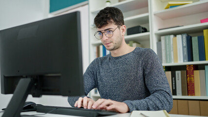 Sticker - Young hispanic man student using computer studying at library university