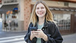 © Krakenimages.com - Young blonde woman using smartphone smiling at coffee shop terrace