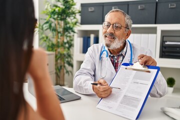 Poster - Senior grey-haired man doctor and patient having medical consultation at clinic