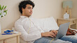 © Krakenimages.com - Young latin man business worker having video call sitting on bed at hotel room
