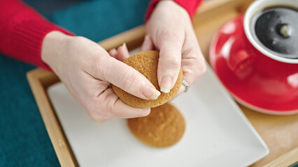 Canvas Print - Young hispanic woman breaking cookie at dinning room