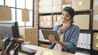 © Krakenimages.com - Young hispanic man ecommerce business worker talking on smartphone using touchpad at office
