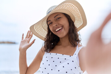 Sticker - Young african american woman wearing summer hat make selfie by camera at seaside