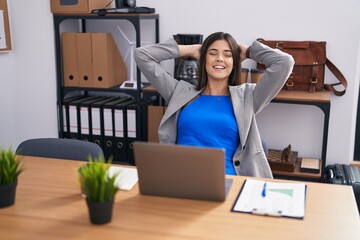 Poster - Young beautiful hispanic woman business worker using laptop relaxed with hands on head at office