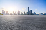 Asphalt road and urban skyline with modern buildings at sunset in Shenzhen, China.