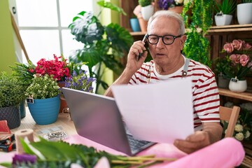 Sticker - Middle age grey-haired man florist talking on smartphone reading document at flower shop