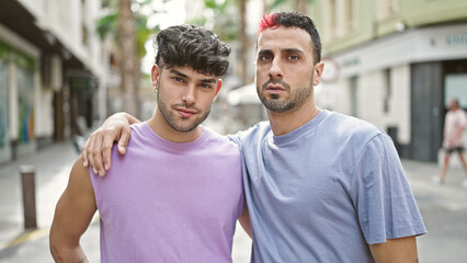 Wall Mural - Two men couple hugging each other with relaxed expression at street