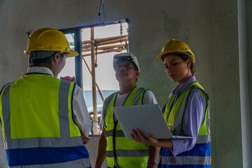 Two female civil engineers and a foreman. Inspecting the building during construction inside construction site