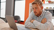 © Krakenimages.com - Young caucasian man using laptop sitting on table with sad express at dinning room