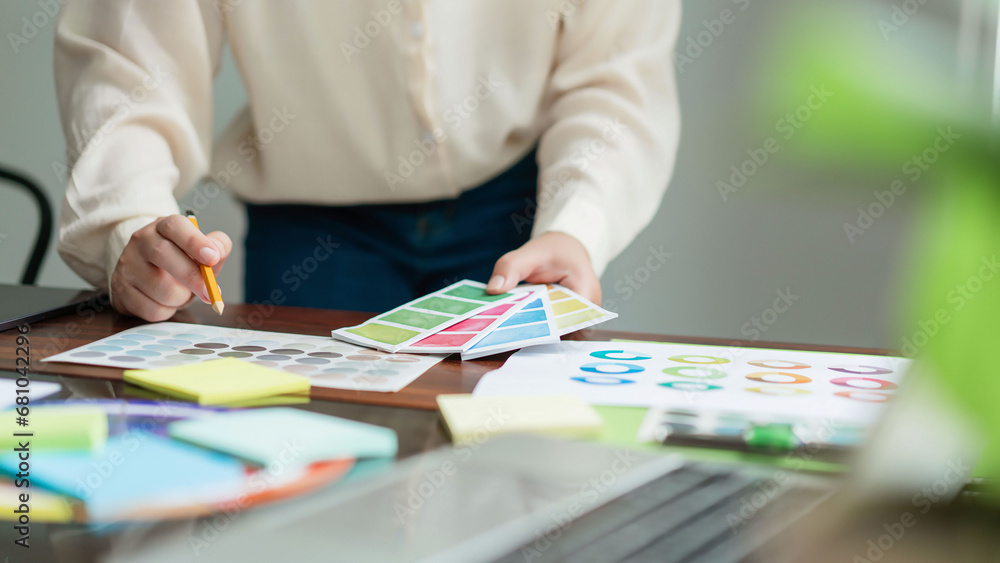 Creative graphic designer holding color sample and comparing color ...