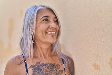 Poster - Middle age grey-haired woman smiling confident looking to the side over isolated white background