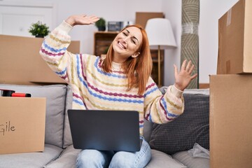 Wall Mural - Young caucasian woman smiling confident using laptop at new home