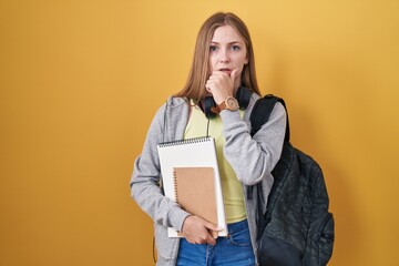 Canvas Print - Young caucasian woman wearing student backpack and holding books thinking worried about a question, concerned and nervous with hand on chin