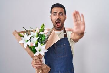 Sticker - Hispanic man with beard working as florist doing stop gesture with hands palms, angry and frustration expression