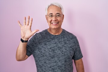 Poster - Middle age man with grey hair standing over pink background showing and pointing up with fingers number five while smiling confident and happy.