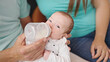 Caucasian baby girl drinking milk from feeding bottle