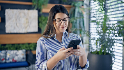 Poster - Young beautiful hispanic woman smiling happy using smartphone at the office