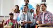 © NDABCREATIVITY - Cheerful and happy group of friends watching olympic games on tv.