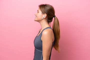 Wall Mural - Young sport caucasian woman isolated on pink background laughing in lateral position