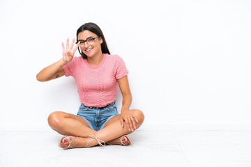 Wall Mural - Young caucasian woman sitting on the floor isolated on white background happy and counting four with fingers