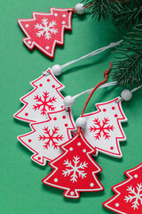 Wall Mural - Red and white Christmas tree toys close up on a green background.