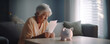 Panoramic shot of worried old woman holding bills in hand with piggy bank close to her