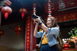 © Natee Meepian - Young beautiful woman asian in market and took her camera up take a photo. woman tourist with camera photo to take in market