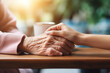 Taking care of the elderly. Hand of young woman holding the hand of old woman with tenderness