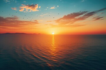 Wall Mural -  a large body of water at sunset with birds flying in the sky over the water and the sun setting in the distance.