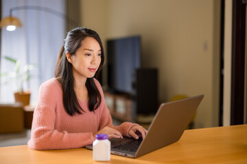 Canvas Print - Woman use laptop computer for checking the daily supplement