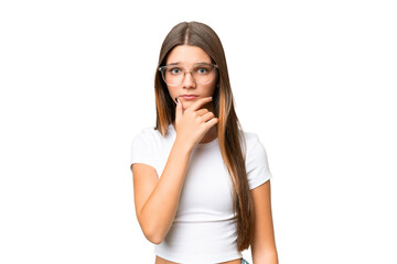 Sticker - Teenager caucasian girl over isolated background having doubts