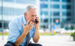 © Minerva Studio - Senior business man yelling at the phone outdoor, sitting on a bench