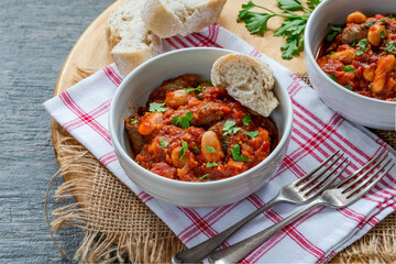 Canvas Print - Beef chipolatas and bean casserole with crusty bread