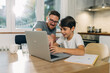© cherryandbees - Father and son using laptop together.