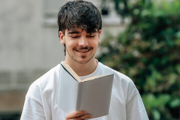 Canvas Print - young man with book on the street outdoors