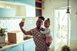 © Marko Geber - Woman holding little daughter taking selfie on moving day