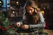 Young Cute smiling Woman designer preparing Christmas Evergreen Tree Wreath. Manufacturer of Christmas decor with their own hands. Christmas wreath for the holiday. The new year celebration. Closeup