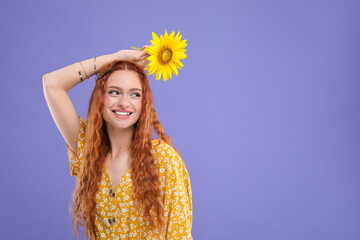 Poster - Beautiful young hippie woman with sunflower on violet background, space for text